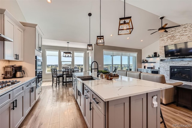 229 High Meadows Loop, Elizabeth, CO 80107 - kitchen with open floor plan, an island with sink, light wood-type flooring, a kitchen bar, and high vaulted ceiling