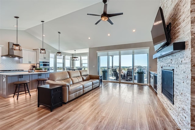 229 High Meadows Loop, Elizabeth, CO 80107 - living room featuring high vaulted ceiling, a fireplace, light wood-style floors, and ceiling fan