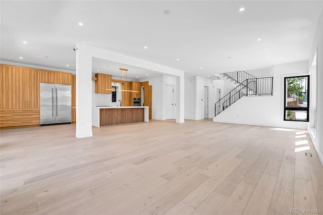 1491 S York St, Denver, CO 80210 - unfurnished living room featuring light wood-type flooring, stairs, and recessed lighting
