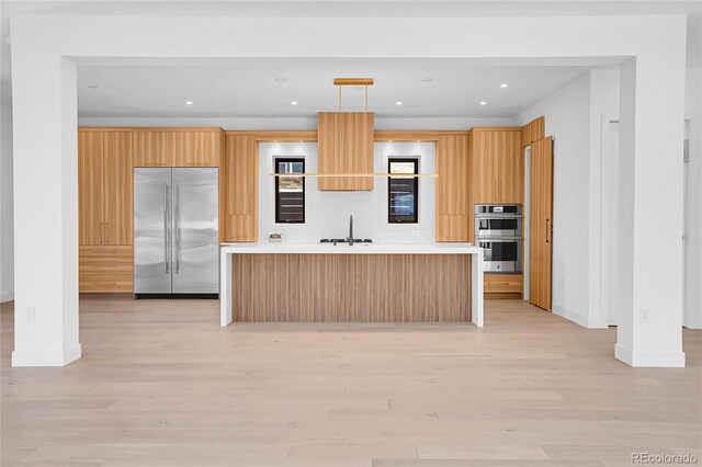 1491 S York St, Denver, CO 80210 - kitchen with appliances with stainless steel finishes, modern cabinets, an island with sink, light countertops, and recessed lighting