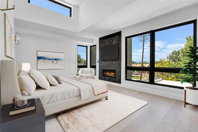 1491 S York St, Denver, CO 80210 - bedroom featuring a towering ceiling, light wood-style flooring, and a fireplace