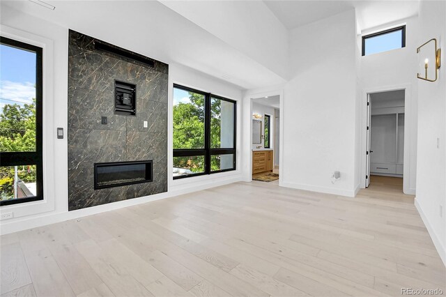 1491 S York St, Denver, CO 80210 - unfurnished living room with light wood-style floors and a high end fireplace