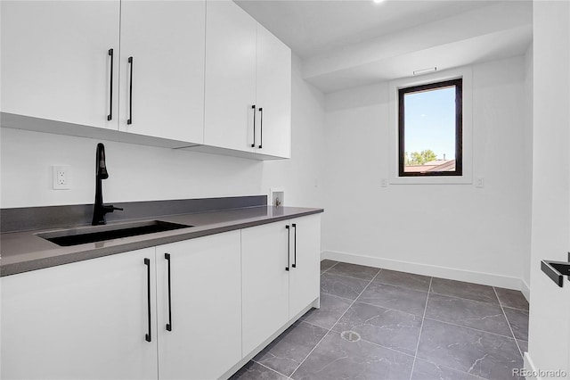 1491 S York St, Denver, CO 80210 - kitchen with dark countertops, white cabinetry, and dark marble finish floors