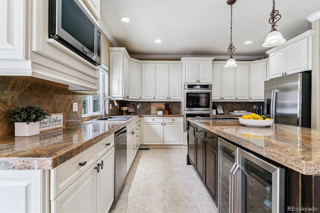 kitchen featuring pendant lighting, white cabinets, beverage cooler, stainless steel appliances, and sink