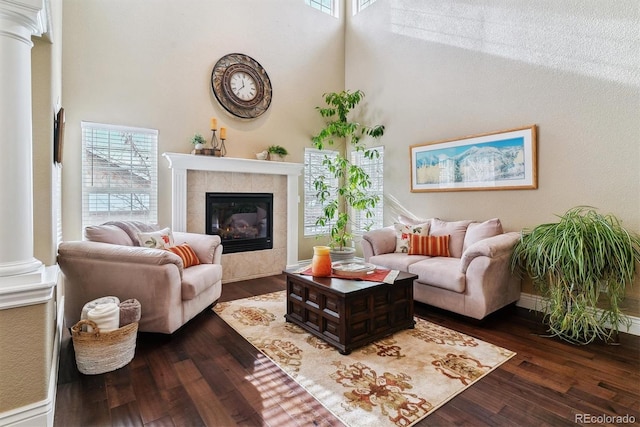 living room featuring decorative columns, a towering ceiling, and a wealth of natural light