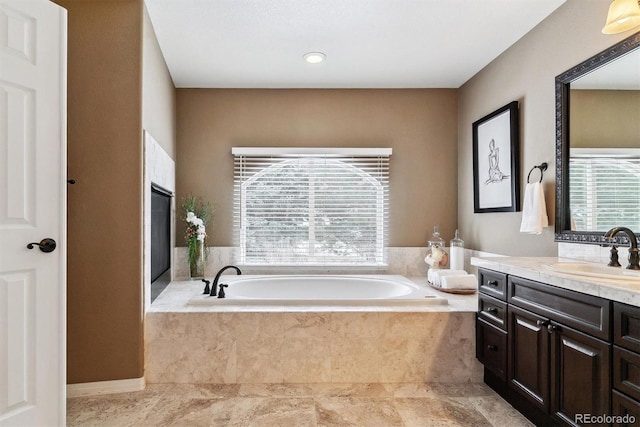 bathroom with vanity and a relaxing tiled tub