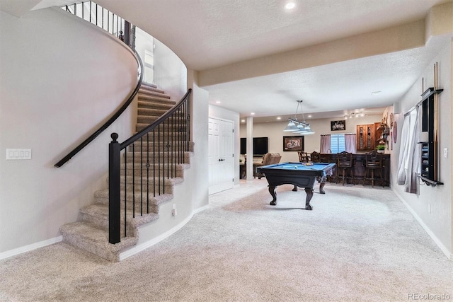 game room with carpet floors, a textured ceiling, pool table, and bar