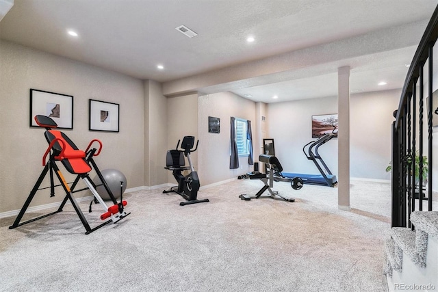 exercise area with a textured ceiling and light carpet