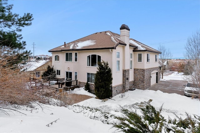 snow covered property featuring a garage