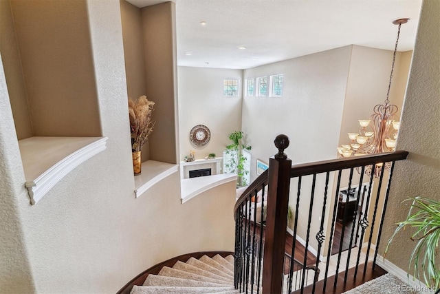 stairway featuring hardwood / wood-style flooring and a chandelier