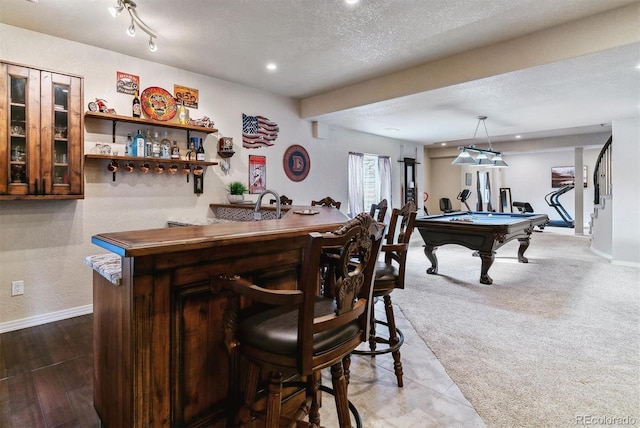 bar with a textured ceiling, billiards, carpet floors, dark brown cabinets, and decorative light fixtures