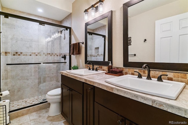 bathroom with tile patterned flooring, an enclosed shower, toilet, vanity, and decorative backsplash