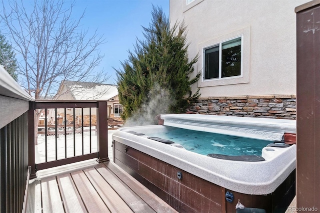 wooden deck featuring a hot tub