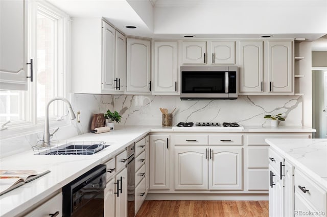 2209 Green Oaks Ln, Greenwood Village, CO 80121 - kitchen featuring stainless steel microwave, black dishwasher, a sink, white stovetop, and decorative backsplash