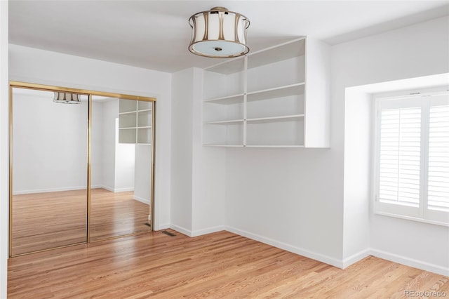 2209 Green Oaks Ln, Greenwood Village, CO 80121 - unfurnished bedroom with wood finished floors, a closet, baseboards, and multiple windows