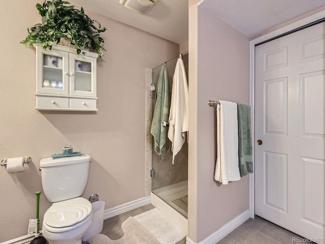 2676 S Troy Ct, Aurora, CO 80014 - bathroom featuring a stall shower, tile patterned flooring, toilet, and baseboards