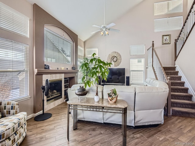 living room with stairway, wood finished floors, and a healthy amount of sunlight