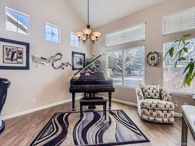 2676 S Troy Ct, Aurora, CO 80014 - living area with high vaulted ceiling, a notable chandelier, baseboards, and wood finished floors