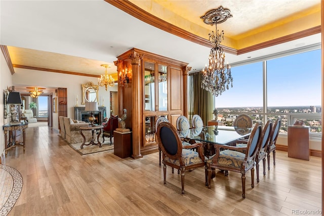 dining space featuring light hardwood / wood-style floors, crown molding, and a notable chandelier