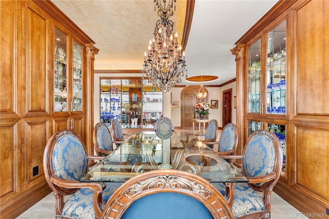 dining space with a wealth of natural light, light hardwood / wood-style flooring, crown molding, and a notable chandelier