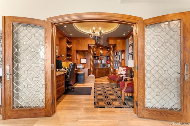 wine cellar with light hardwood / wood-style flooring, a raised ceiling, and a chandelier