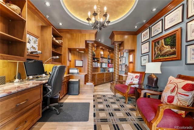 office space with light hardwood / wood-style floors, a chandelier, wooden walls, ornate columns, and a tray ceiling