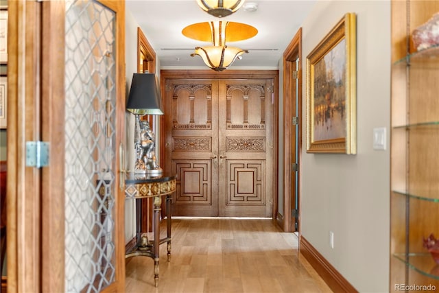 hallway featuring light hardwood / wood-style flooring and crown molding