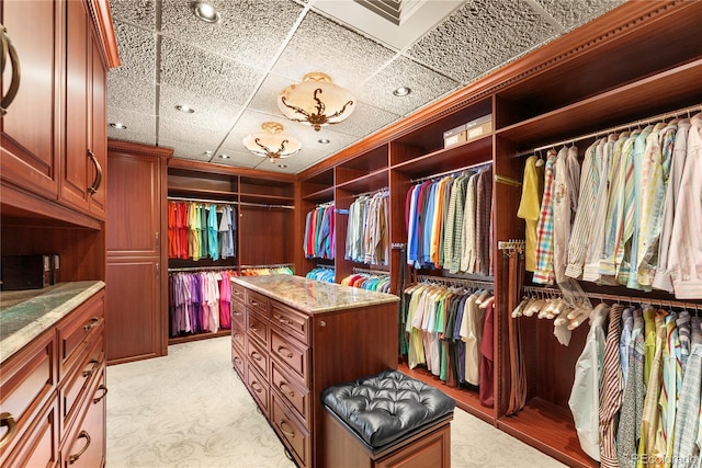 spacious closet with light carpet and a drop ceiling