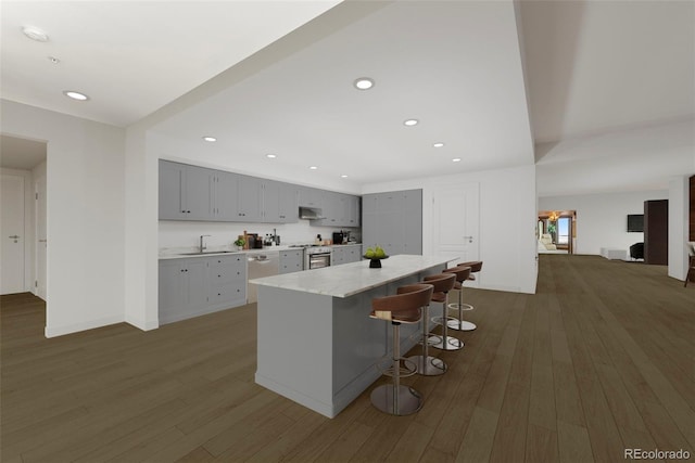 kitchen with sink, range, a kitchen island, dark wood-type flooring, and a breakfast bar