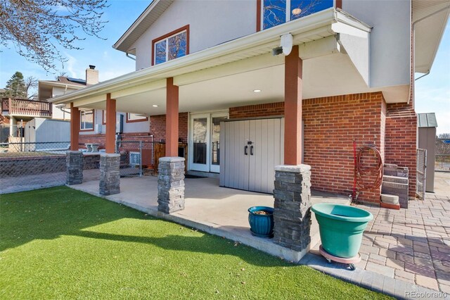 back of property with brick siding, stucco siding, and fence