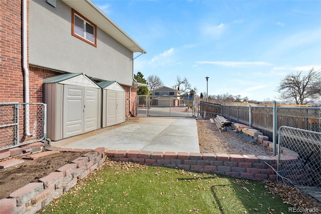 view of patio / terrace featuring a gate, an outbuilding, fence, and a shed