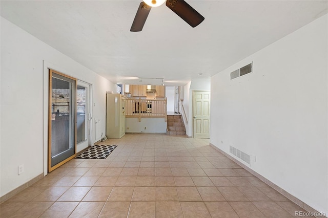 unfurnished living room with stairs, light tile patterned flooring, visible vents, and ceiling fan