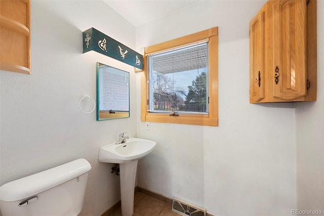 bathroom featuring tile patterned floors, visible vents, baseboards, and toilet