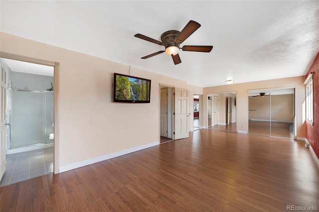 empty room with ceiling fan, baseboards, and wood finished floors