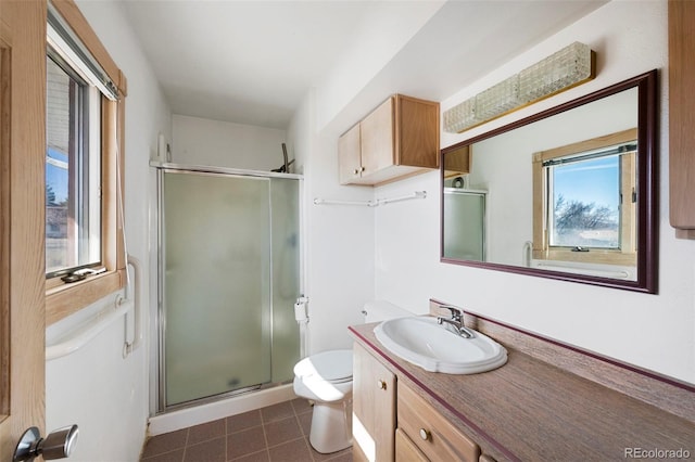 bathroom featuring toilet, a stall shower, vanity, and tile patterned flooring