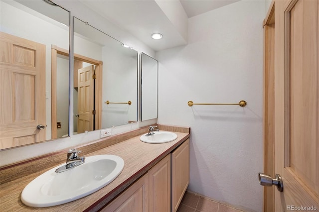 full bath with a sink, double vanity, and tile patterned floors