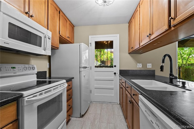 3720 S Fairplay Way, Aurora, CO 80014 - kitchen featuring white appliances, a sink, brown cabinets, and dark countertops