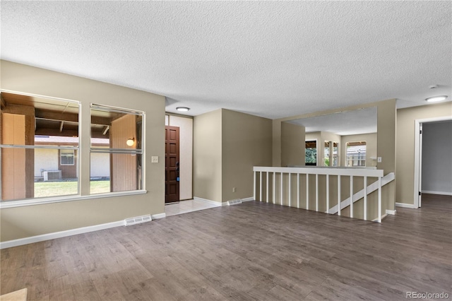 3720 S Fairplay Way, Aurora, CO 80014 - unfurnished room with wood finished floors, a textured ceiling, and baseboards