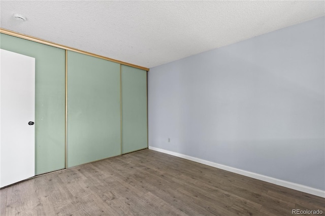 3720 S Fairplay Way, Aurora, CO 80014 - unfurnished bedroom with wood finished floors, baseboards, and a closet