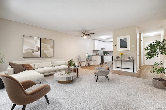 living area featuring light wood finished floors and a ceiling fan