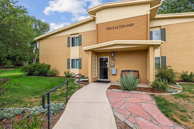 entrance to property featuring a lawn