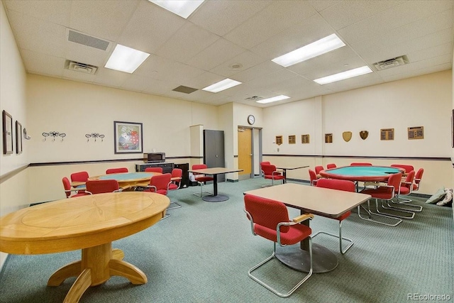 recreation room featuring a drop ceiling and carpet flooring