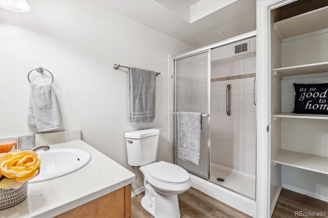 bathroom featuring toilet, a shower with door, vanity, and wood-type flooring