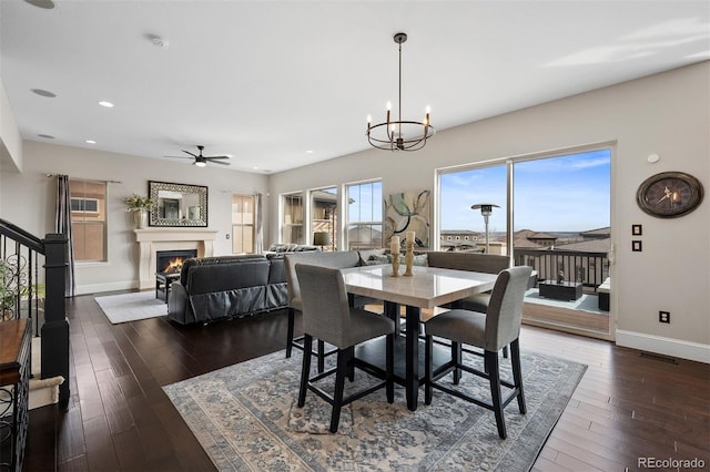 10468 Ladera Dr, Lone Tree, CO 80124 - dining space featuring a lit fireplace, a ceiling fan, dark wood finished floors, a chandelier, and recessed lighting