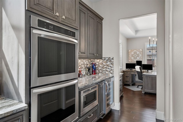 10468 Ladera Dr, Lone Tree, CO 80124 - kitchen with appliances with stainless steel finishes, dark wood-style flooring, tasteful backsplash, wine cooler, and light stone countertops