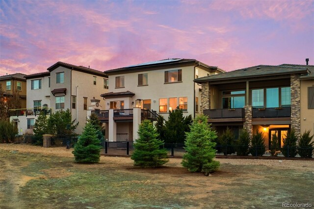 10468 Ladera Dr, Lone Tree, CO 80124 - back of property at dusk featuring stucco siding and stone siding