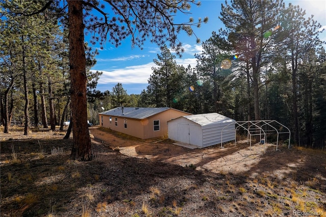 view of side of home featuring an outbuilding and a carport