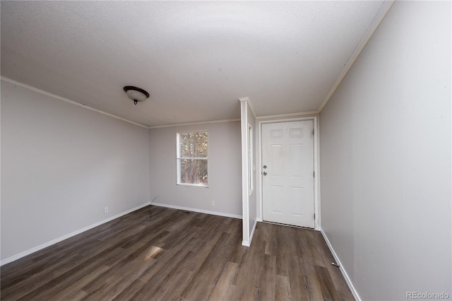 empty room featuring crown molding, a textured ceiling, and dark hardwood / wood-style flooring