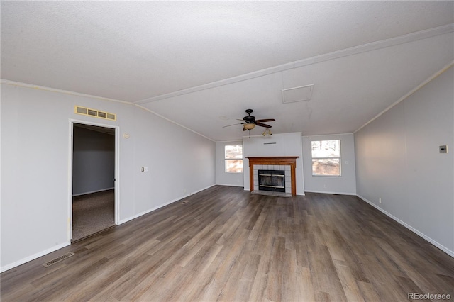 unfurnished living room featuring wood-type flooring, a textured ceiling, a tile fireplace, ceiling fan, and vaulted ceiling