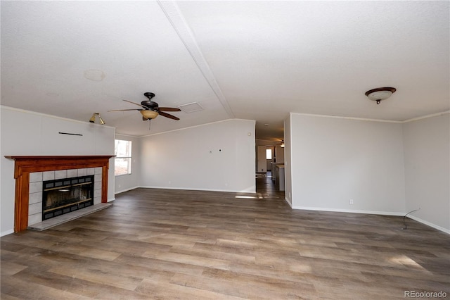 unfurnished living room with ceiling fan, a textured ceiling, hardwood / wood-style flooring, a fireplace, and crown molding